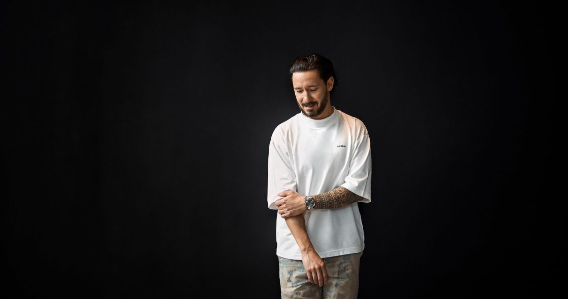 Cédric Grolet With Tattoos Standing In Front Of A Black Background