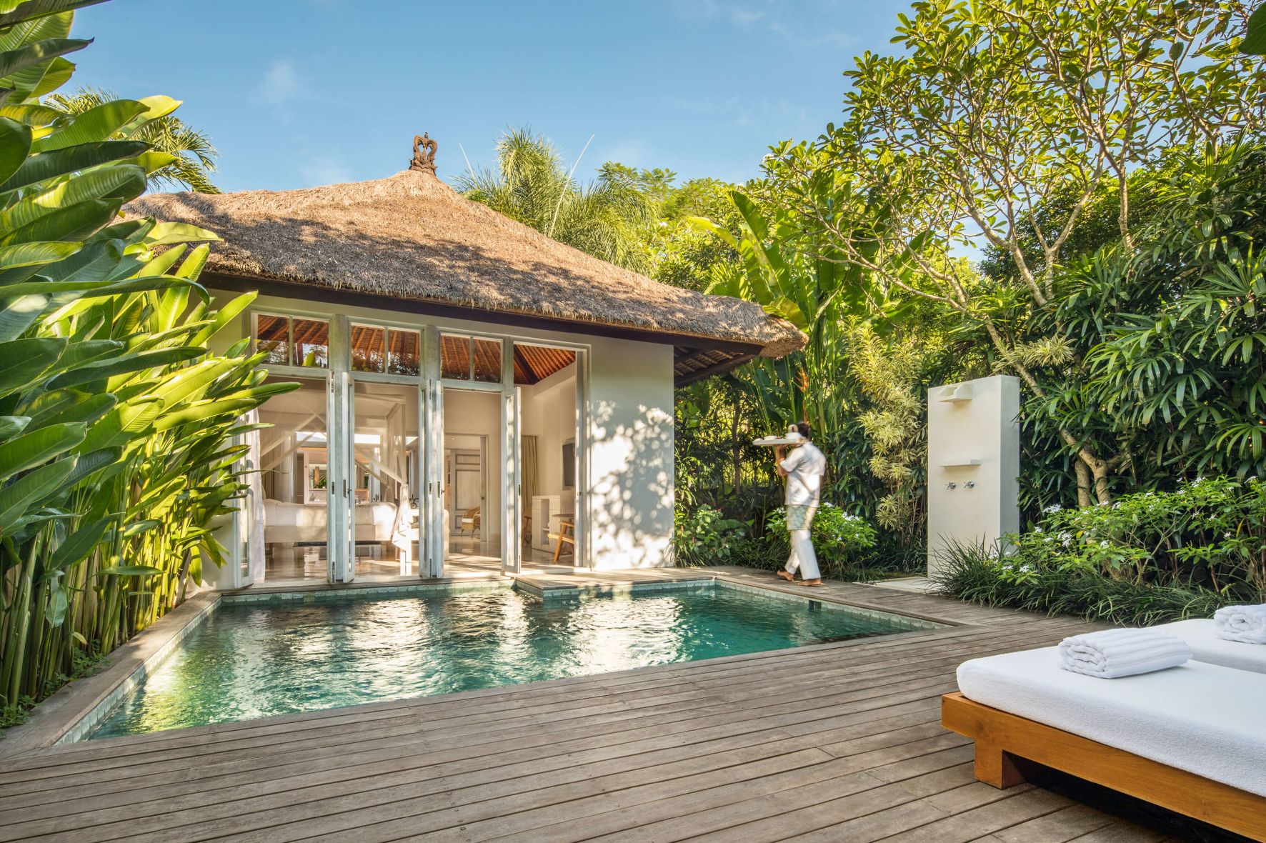 A Person Standing On A Deck Next To A Pool