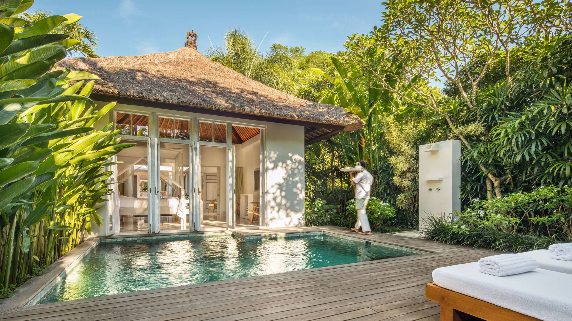 A Person Standing On A Deck Next To A Pool