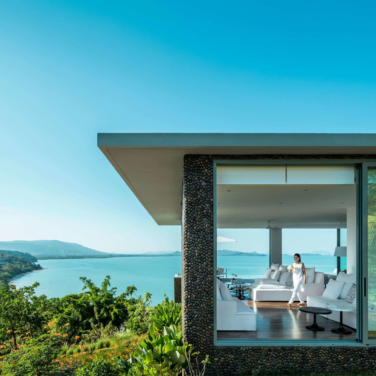 A Person Standing In A Doorway Of A House Overlooking The Ocean