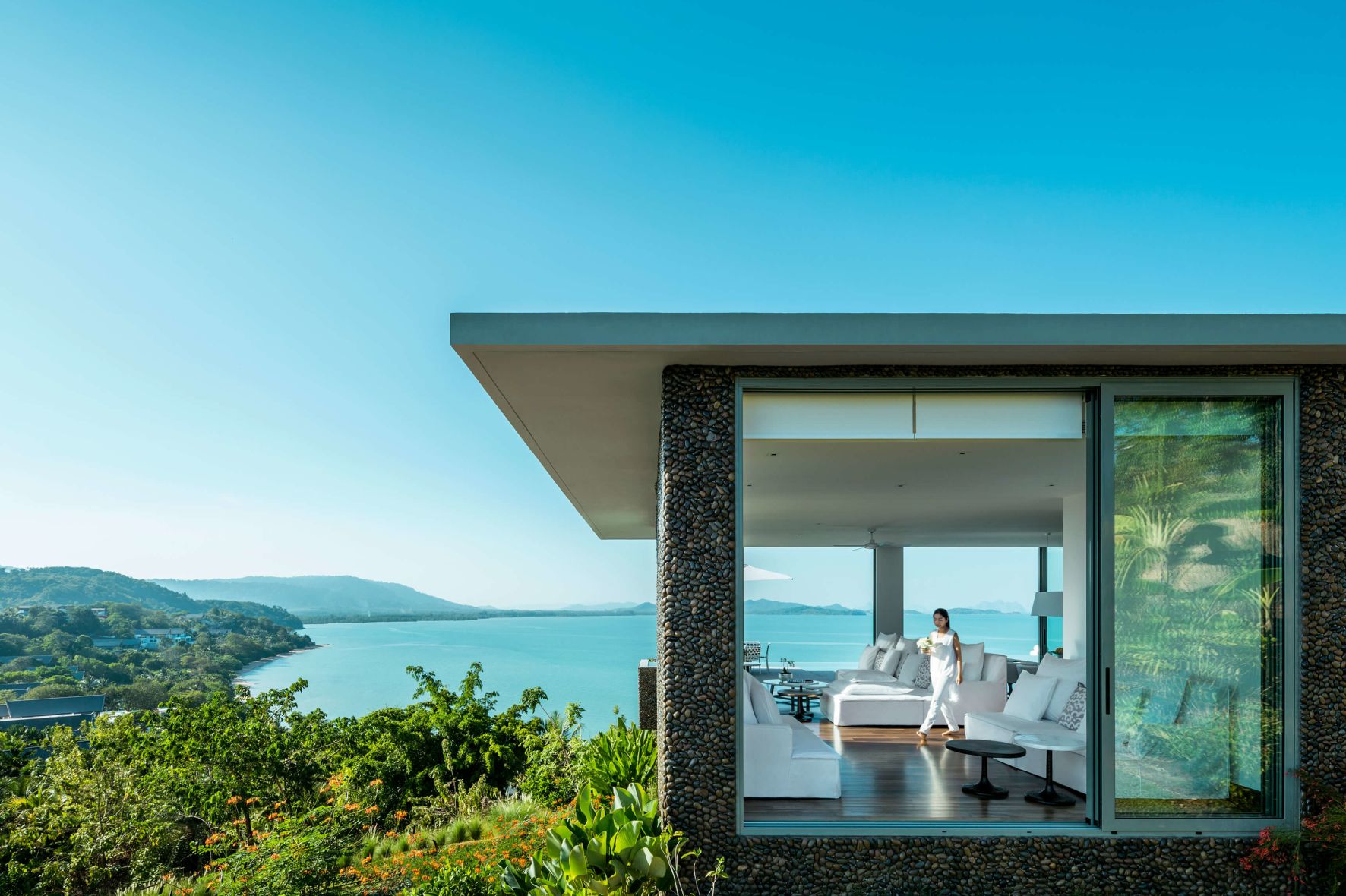 A Person Standing In A Doorway Of A House Overlooking The Ocean